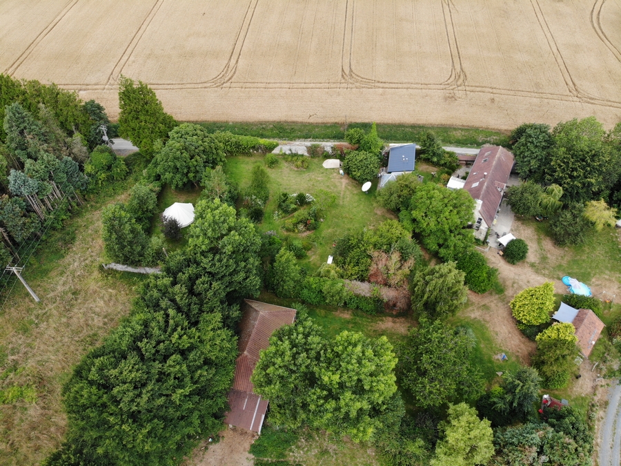 Overzicht terrein vanaf Le Chalet (vooraan), het huis met Le Grenier (rechts boven) en de Mancave (rechts), klein puntje rood van de Trekkershut (rechtsvoor). Op 13 uur zie je de Bergerie en helemaal links de Glamping tent.